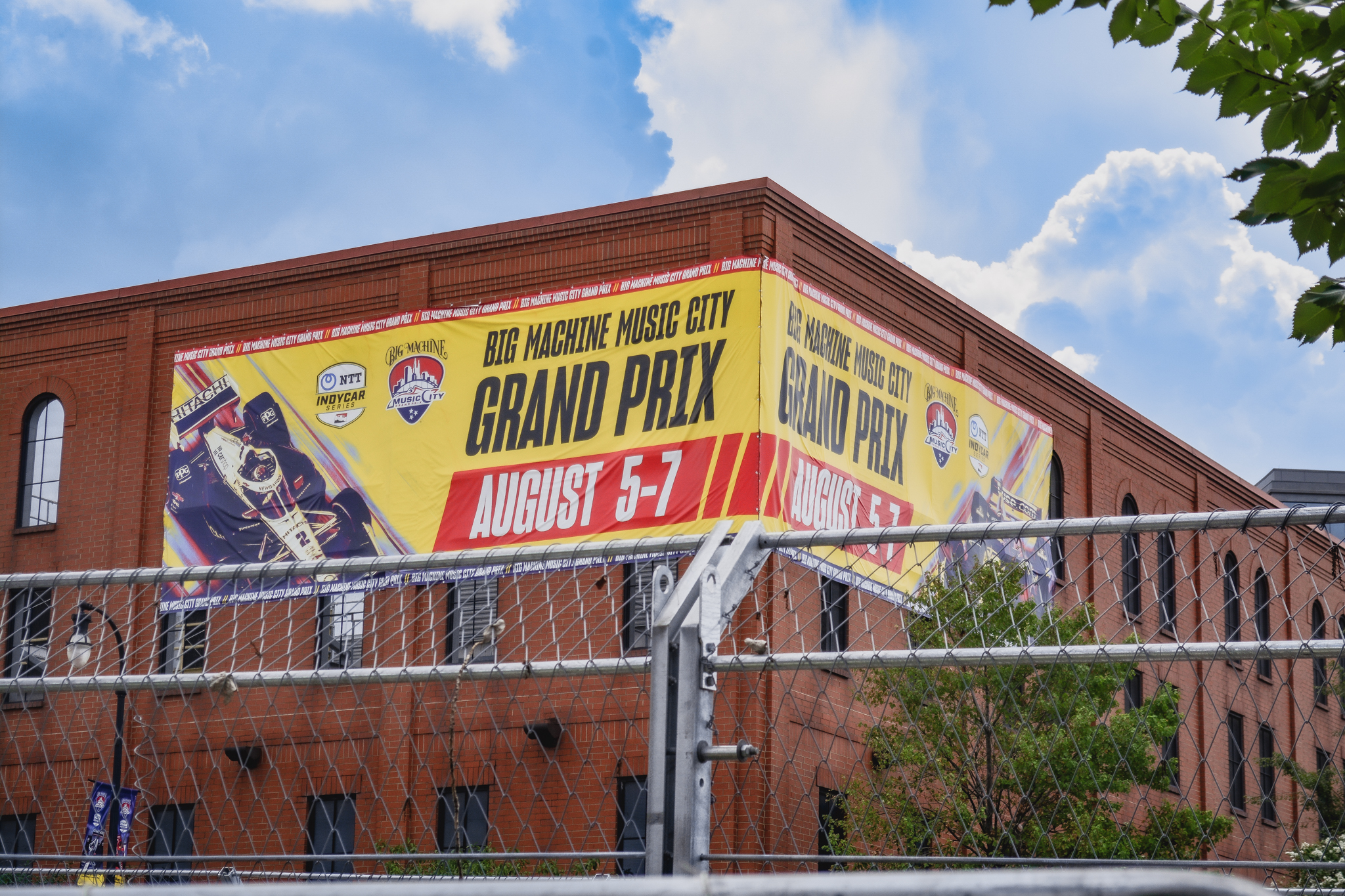 a large sign wrapped around the corner of a building, overlooking the race track